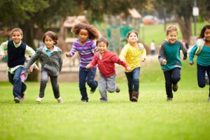 A group of preschoolers running on the playground