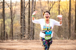 A woman crossing the finish line at the Buck Fifty