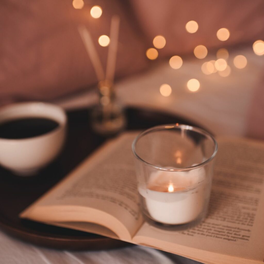 Picture of candle, book and cup of hot coffee for a relaxing moment. 