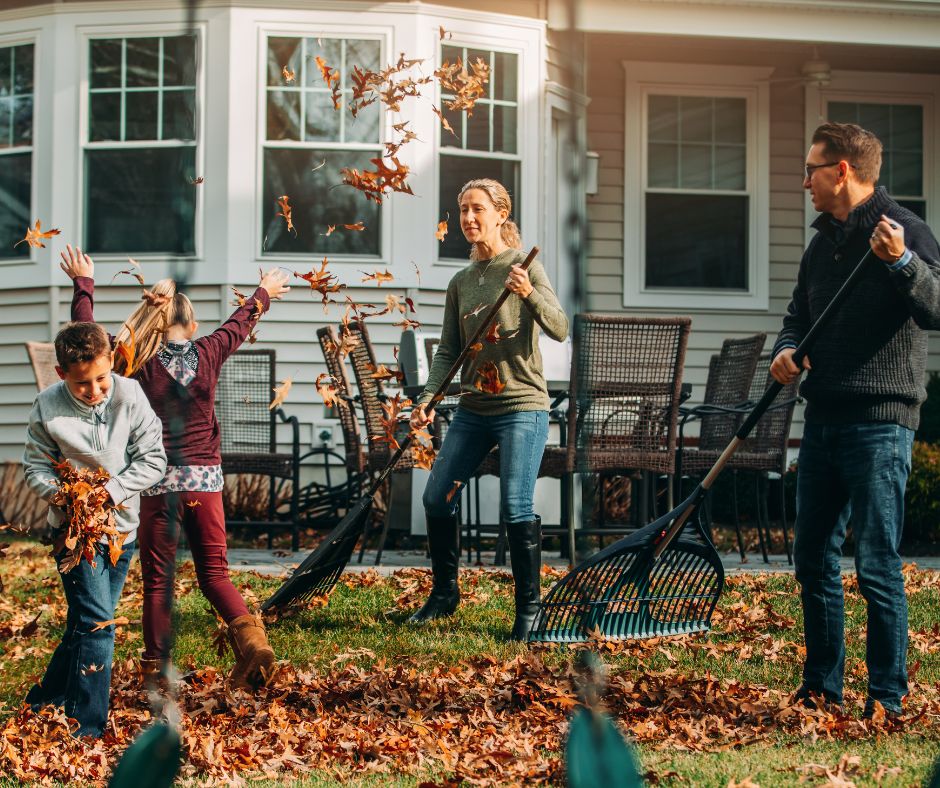 Family raking leaves to stay fit during chilly and shorter days. 