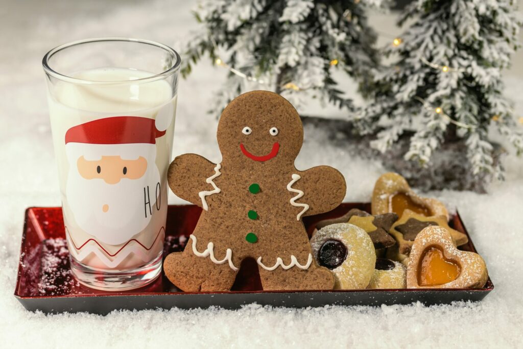 A tray for Santa with a glass of milk in a santa glass, a gingerbread man and assorted cookies