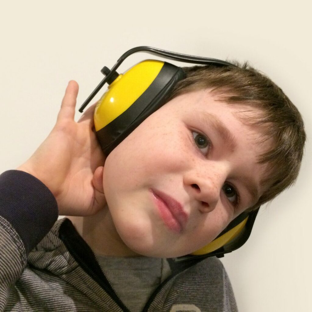 An autistic child using headphones to control his sensory overload